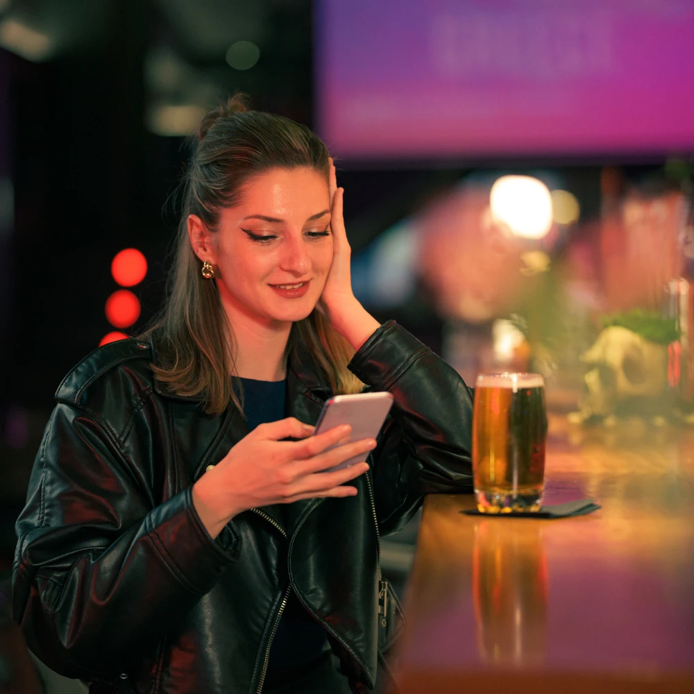 A woman checking her phone in a pub